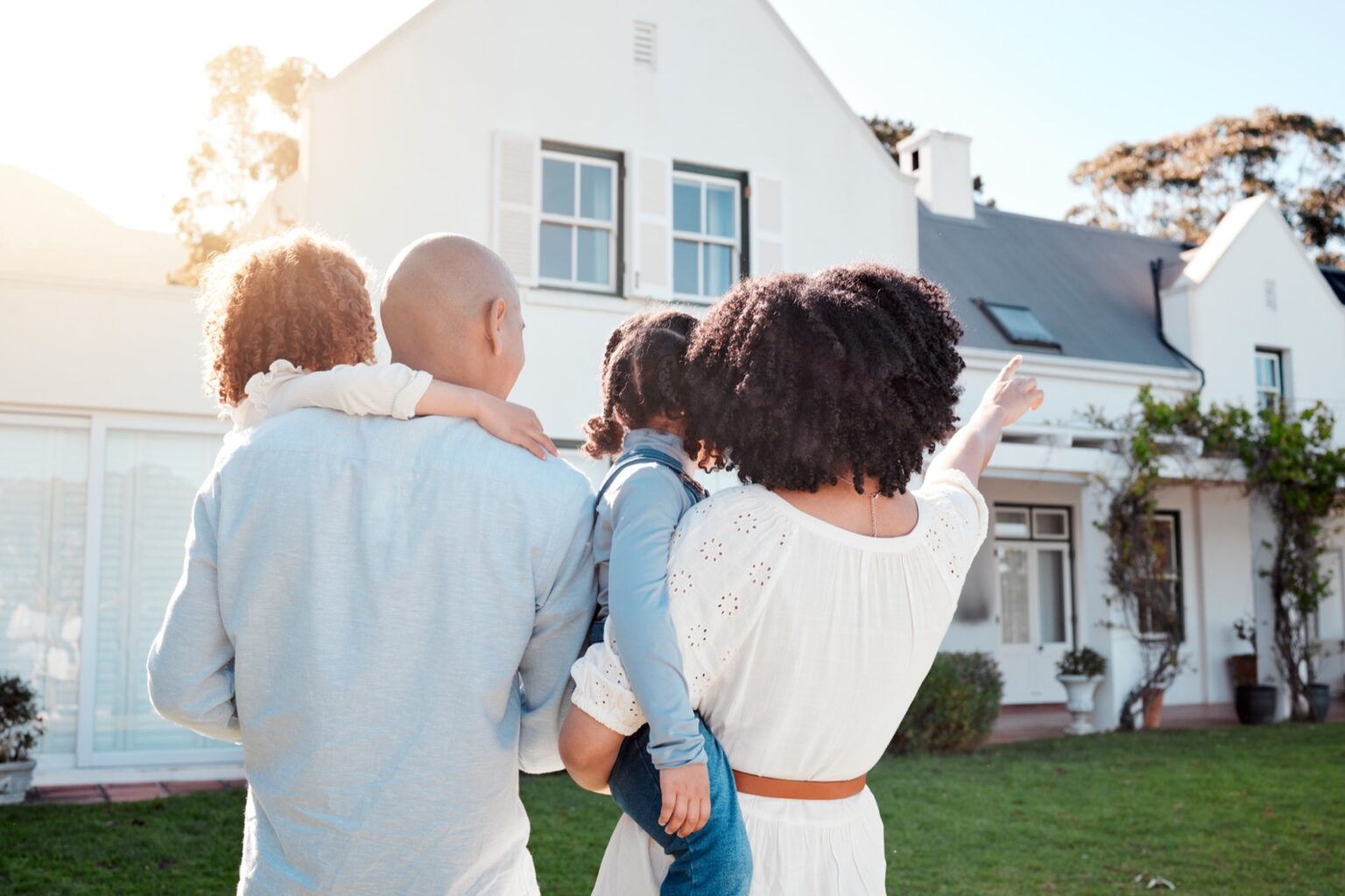 Familie vor ihrem Haus im Grünen